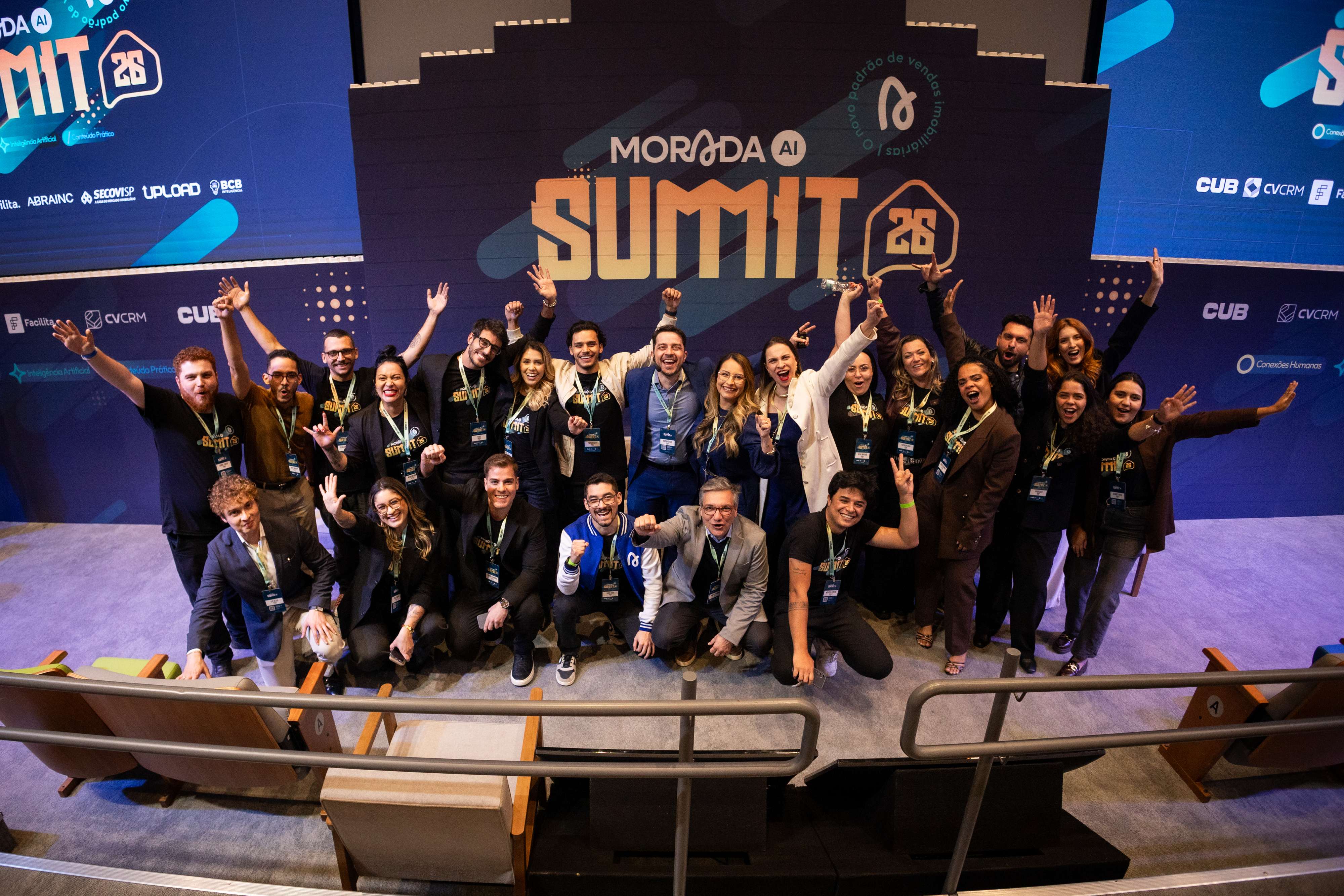 Embaixadores e time Morada.AI reunidos e comemorando no palco do Morada.AI Summit